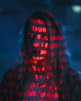 Noia amb codi binari que l'il·lumina. Font: Pexels - cottonbro studio