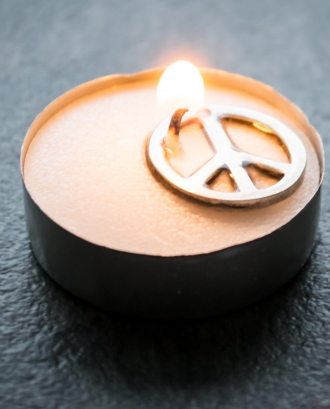 Espelma encesa amb símbol de la pau. Font: Pexels -Steve Johnson
