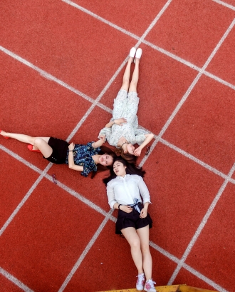 Joves estirats en una pista d'atletisme. Font: Pexels - Zhu Peng