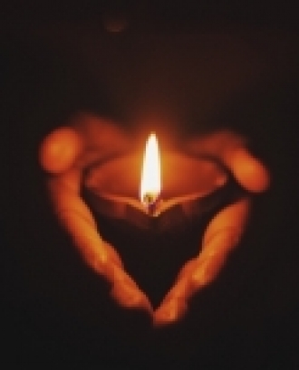 Espelma encesa sostinguda per una mà. Font: Prateek Gautam